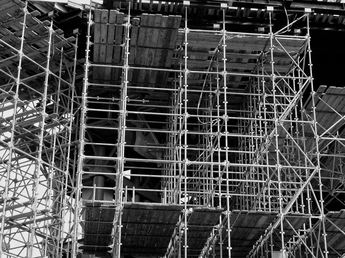 Steel scaffolding and timber decks on a building site at Oosterdokseiland, Amsterdam, in black and white.